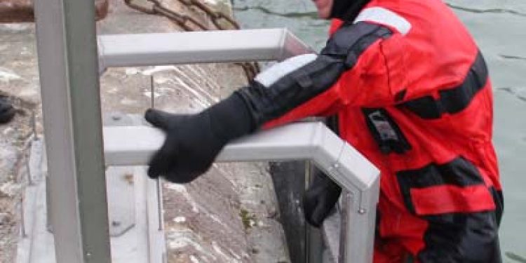 Dansk opfindelse skal minimerer de mange drukneulykker på havnene .  En frisk frivillig sprang i havnens iskolde vand og beviste dermed sikkerhedsstigens værd.  Foto: Henning Hansen