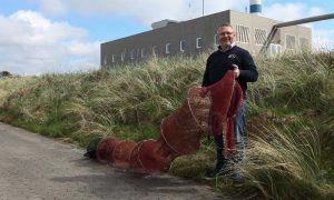 Norsk seminar og konference om rensefisk i havdambrug.  Foto: Salgschef Ole Andersen fra Frydendahl Fiskenet i  Hvide Sande viser her deres ruse til fangst af berggylt frem