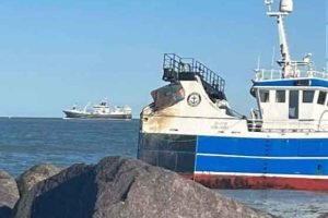 Efter en dramatisk grundstødning ved Nordmolen ved Hirtshals Havn - er besætningen nu reddet sikkert i land med helikopter – nu venter det afgørende øjeblik med højvande og en kontrolleret »warping«. foto: Erik Kronquist