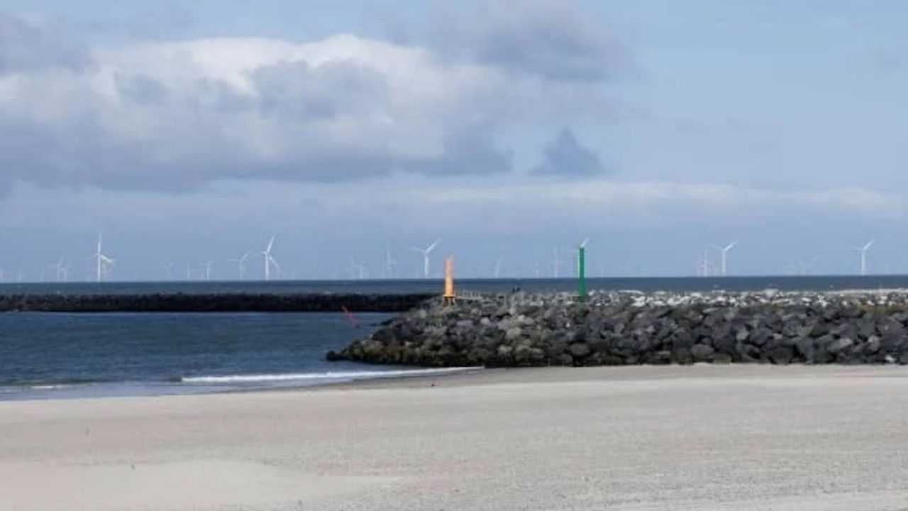 Visualiseringer af havmøller er svære at gengive på papir og på computer, men denne visualisering foretaget på stranden i Hvide Sande, skal vise at de kommende havmøller ude på 20 kilometers afstand tydeligt kan ses bag Vesterhav Syd-møllerne. Ill.: Energistyrelsen.