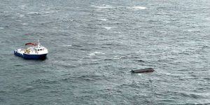 Dette bildet er tatt under redningsaksjonen i Hjeltefjorden onsdag, og viser havaristen samt ett av fartøyene som bisto i redningsaksjonen. Foto: CHC Redningshelikopter Florø