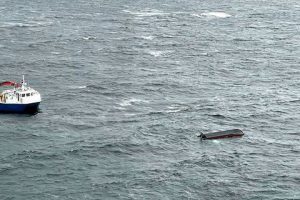 Dette bildet er tatt under redningsaksjonen i Hjeltefjorden onsdag, og viser havaristen samt ett av fartøyene som bisto i redningsaksjonen. Foto: CHC Redningshelikopter Florø