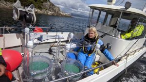 Lille arbejdsbåd på fjorden med udstyr og forskere ombord. Forsker Anne Berit Skiftesvik på vej ud i fjorden med de to specialdesignede drivkamre, der blev brugt i forsøgene. foto: Hi.no